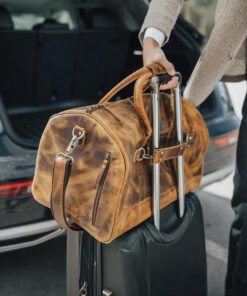 the denali leather duffel bag for men on suitcase